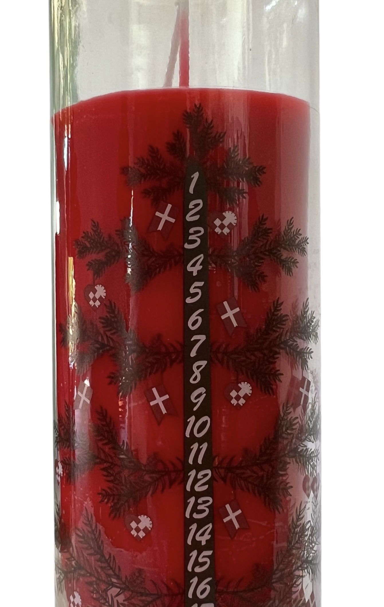 Red calendar candle in glass with Christmas tree